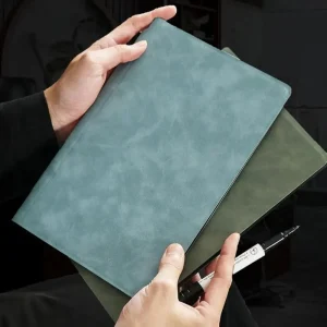 Person holding notebooks and a pen.